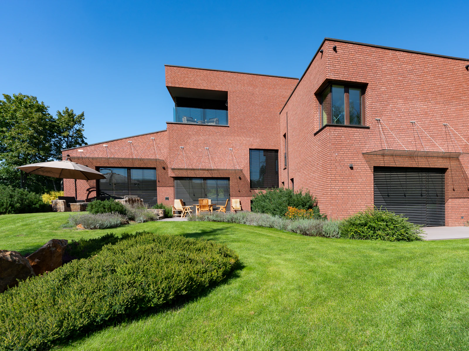 Illustrative photo of a large brick house with a green lawn in front of it