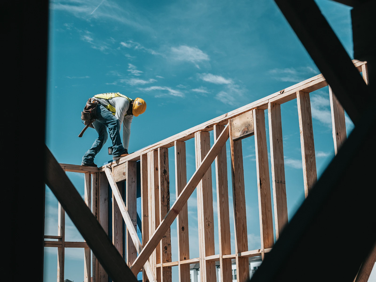 Illustrative photo of construction worker in hard hat on building frame