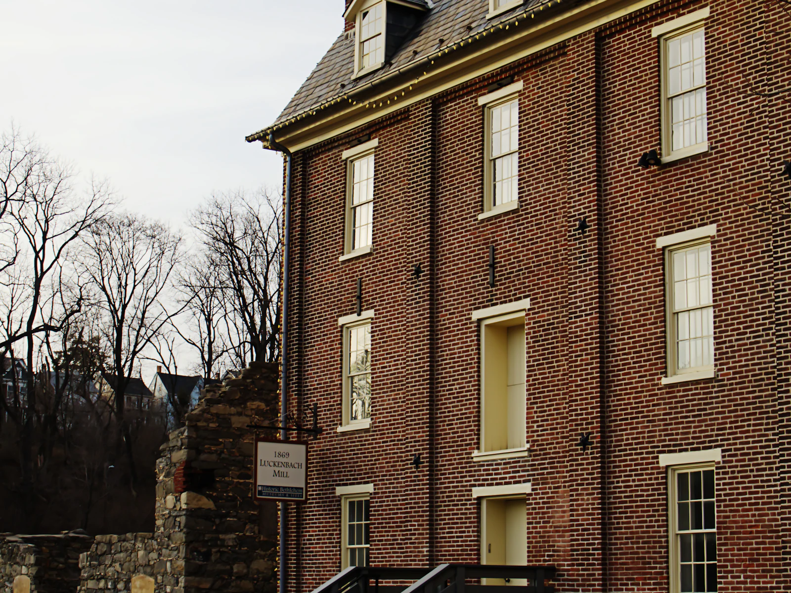Illustrative photo of a brick building with dormers and a stone wall