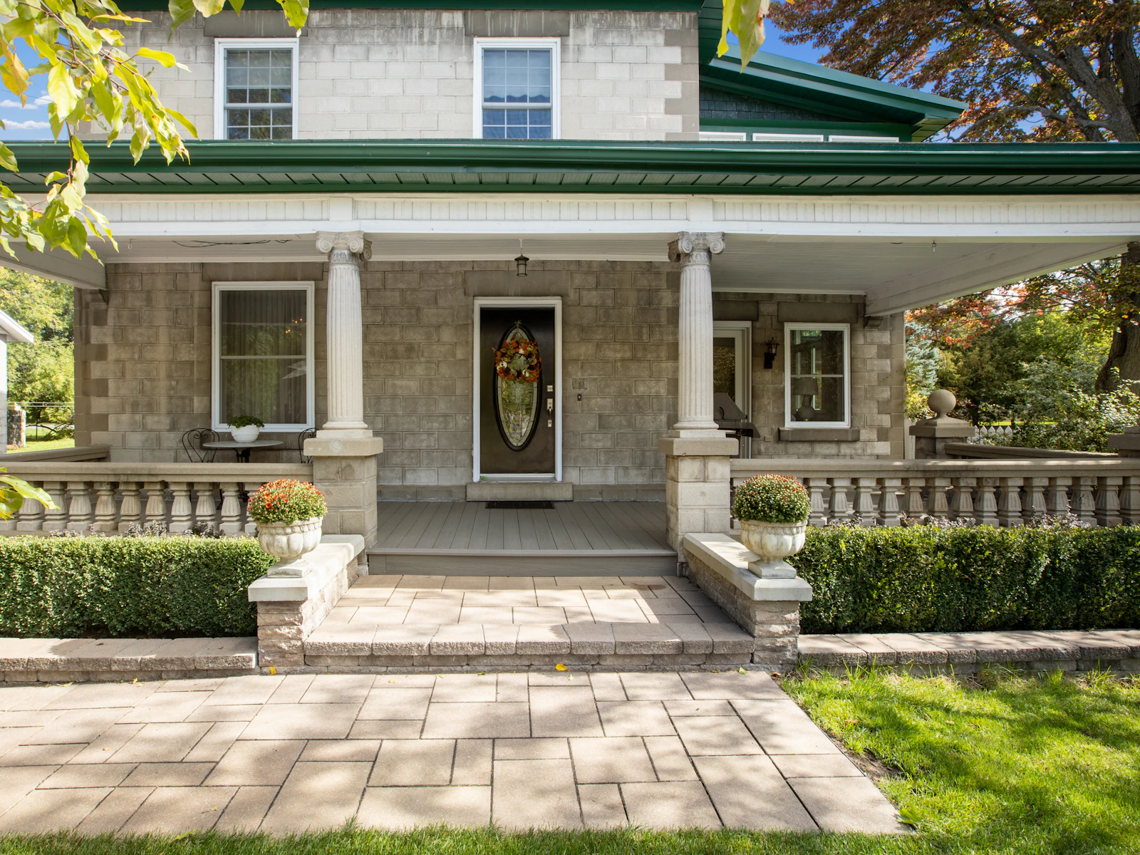 Illustrative photo of a house with a green roof and white pillars