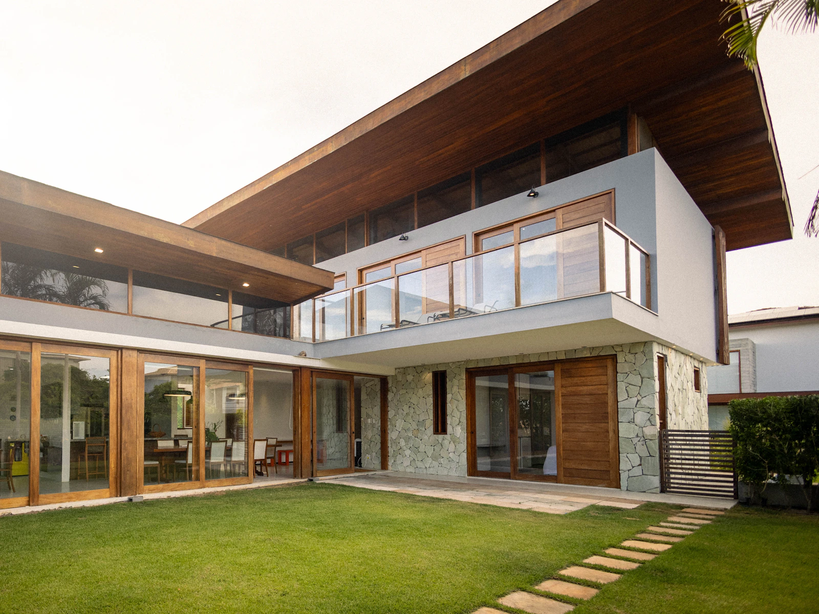 Illustrative photo of modern house with large windows and a green lawn