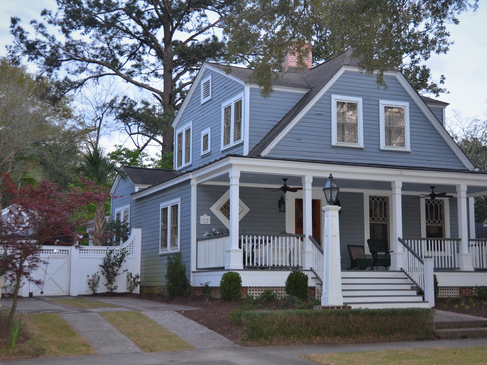 Illustrative photo of white and blue wooden house near green trees during daytime