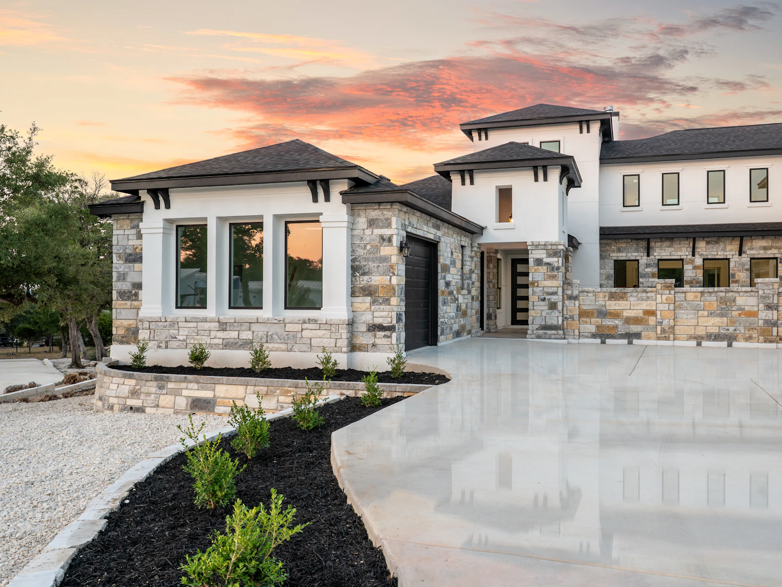 Illustrative photo of a modern luxury house with stone accents at sunset