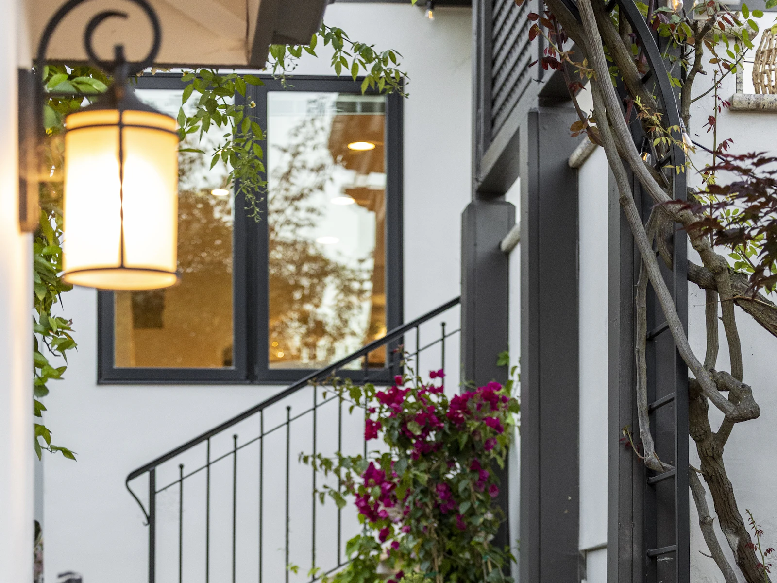 Illustrative photo of stone entry steps with black railing and a lantern