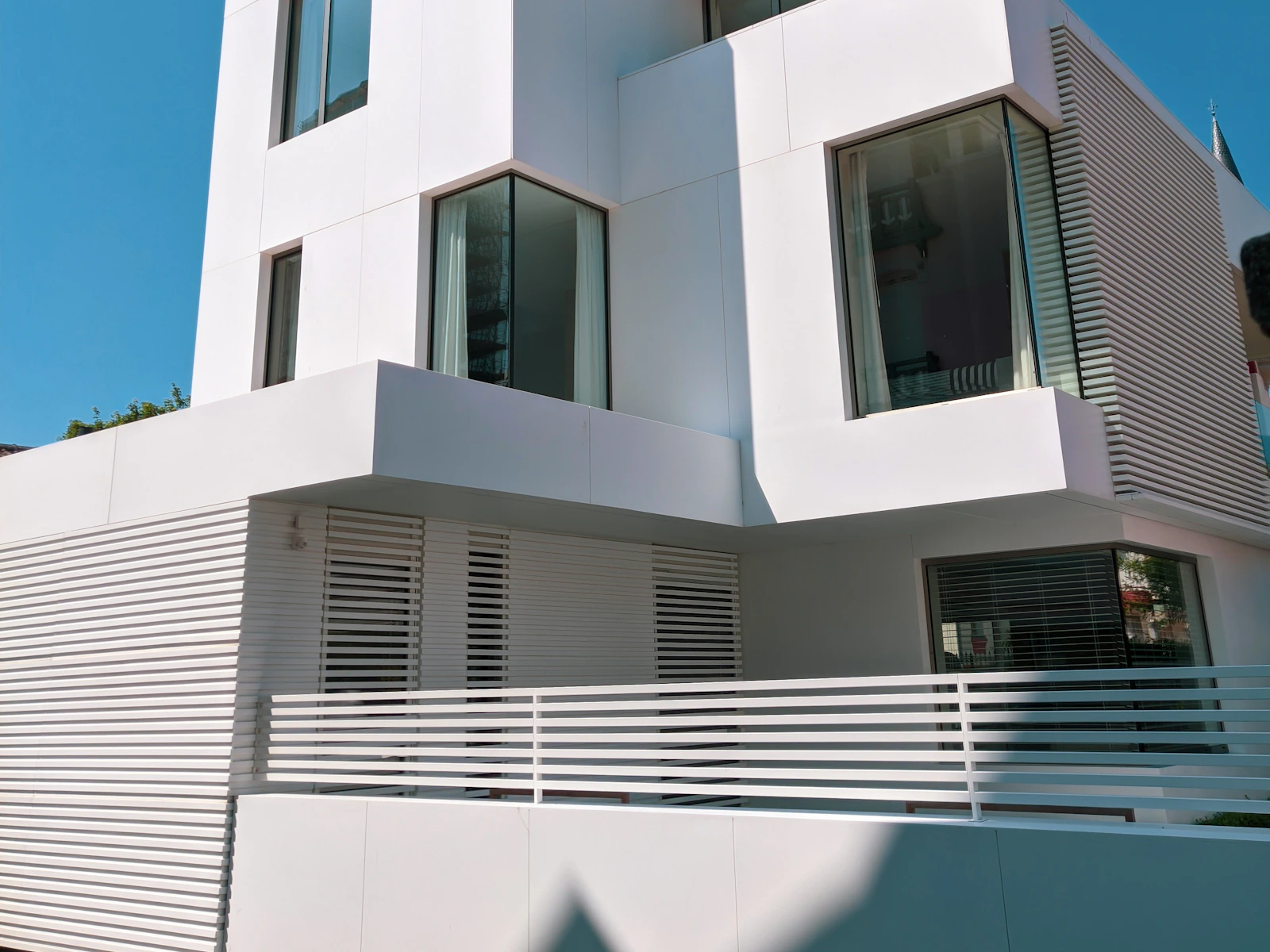 Illustrative photo of a white modern infill home with black-framed windows