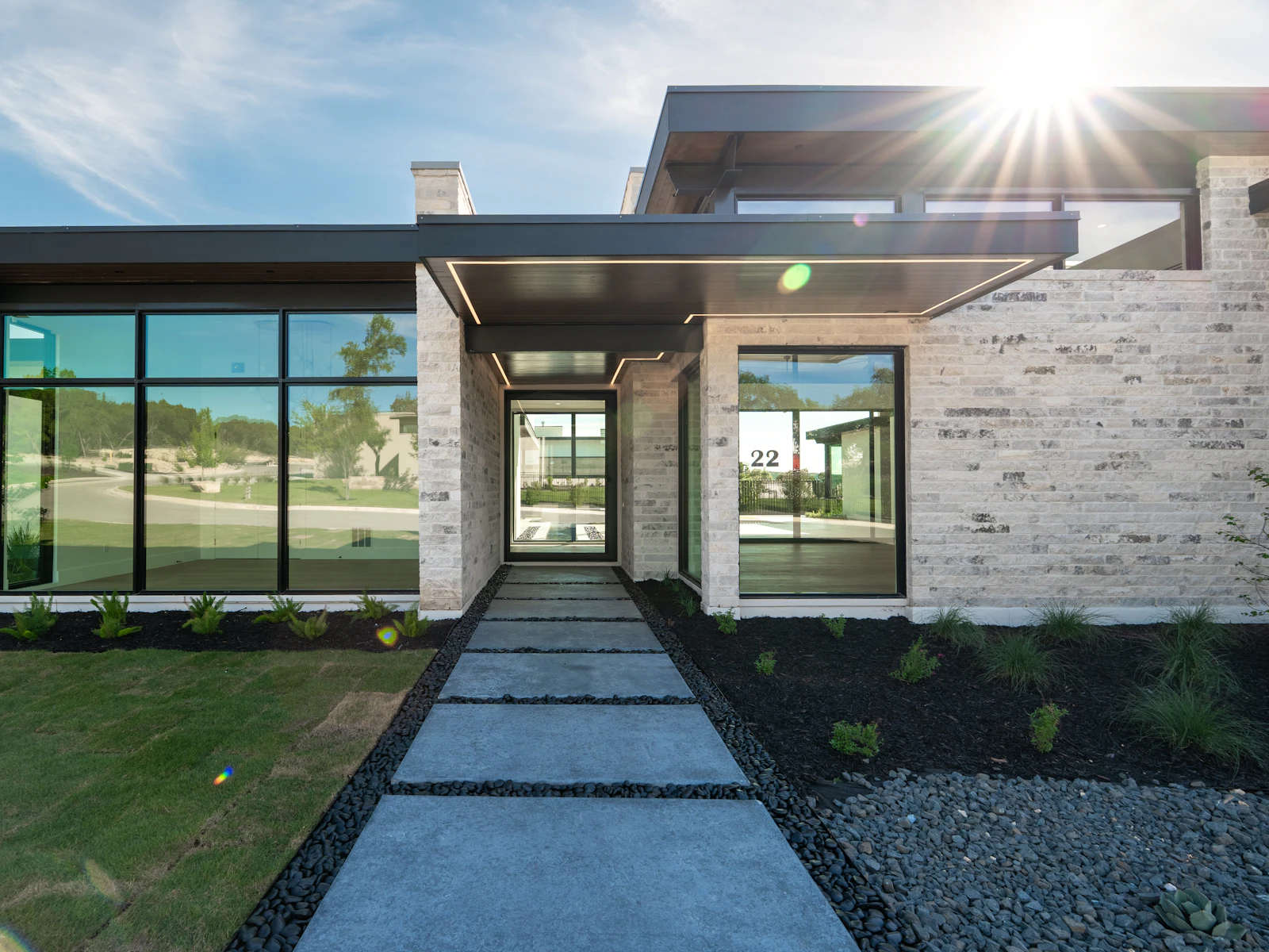 Illustrative photo of a contemporary stone estate with broad glass windows