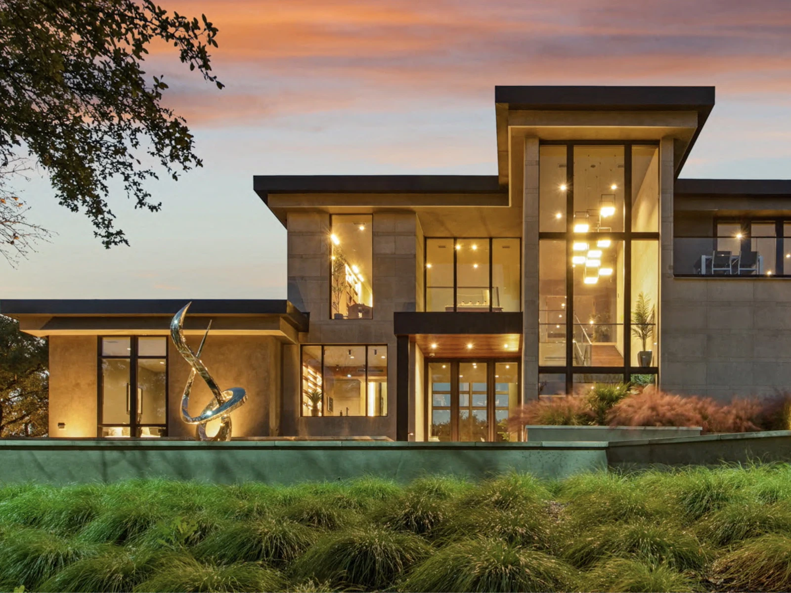 Illustrative photo of a modern luxury home with tall glass walls at dusk