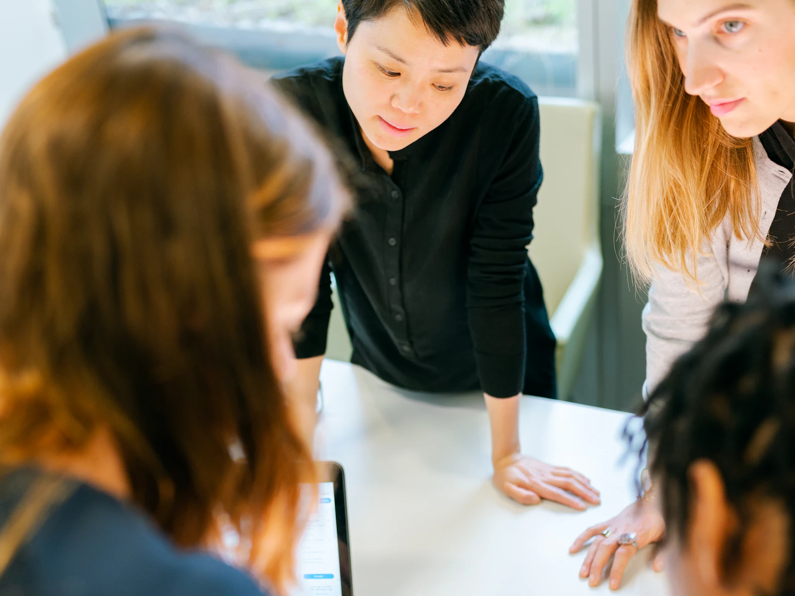Illustrative photo of four people reviewing documents and material samples together