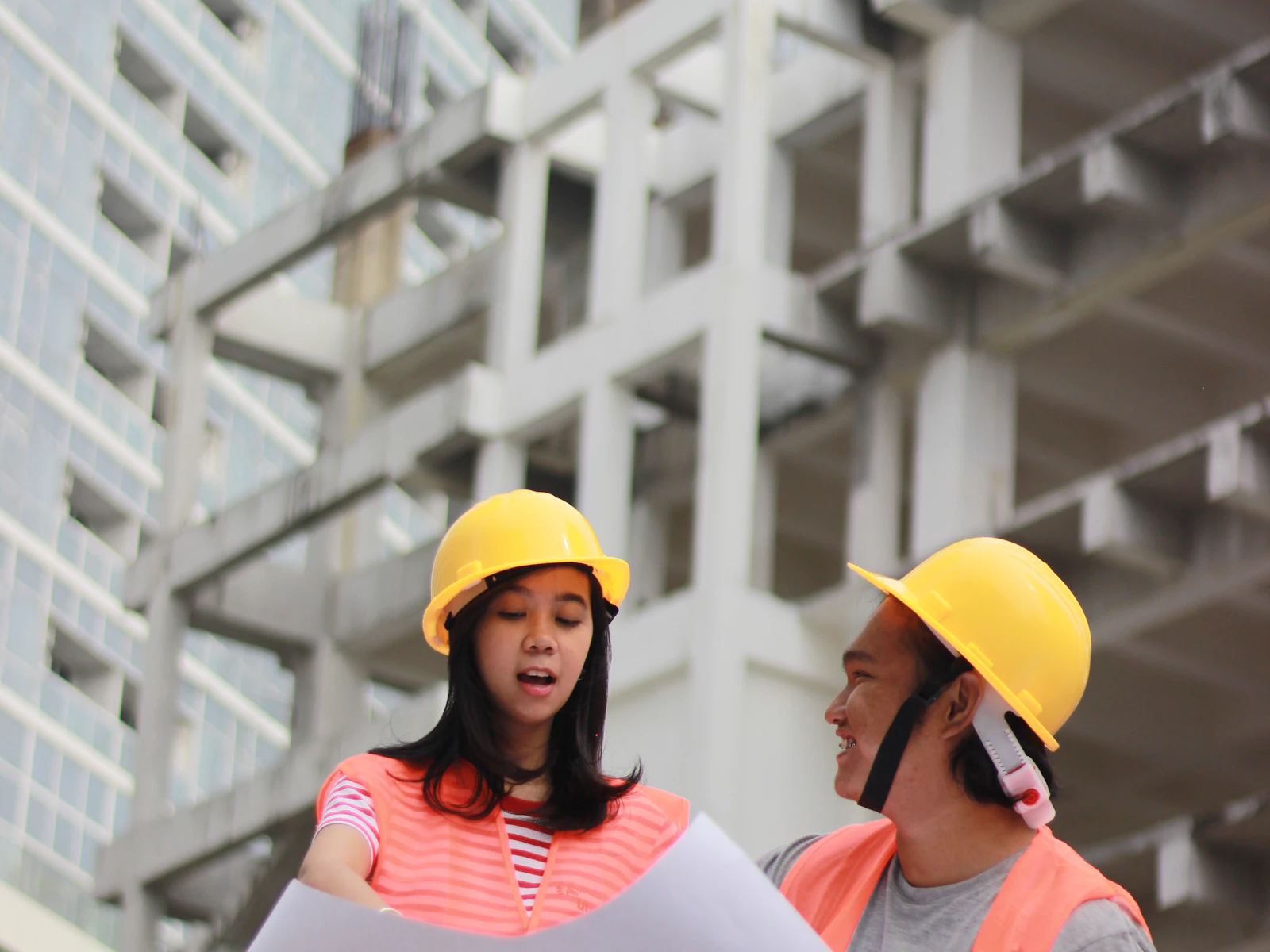 Illustrative photo of two construction professionals reviewing plans at a building site