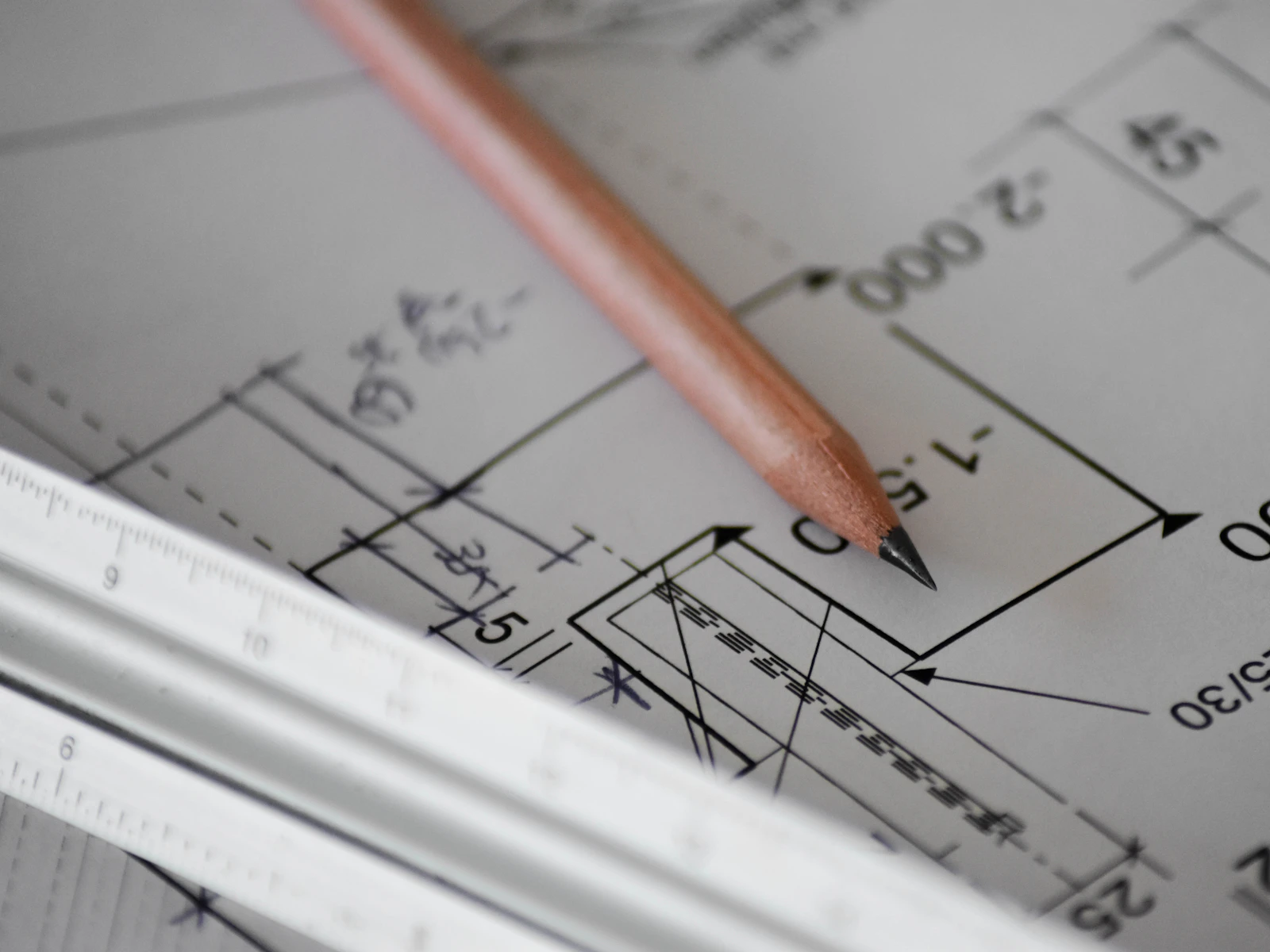 Illustrative photo of a pencil resting on architectural drawings