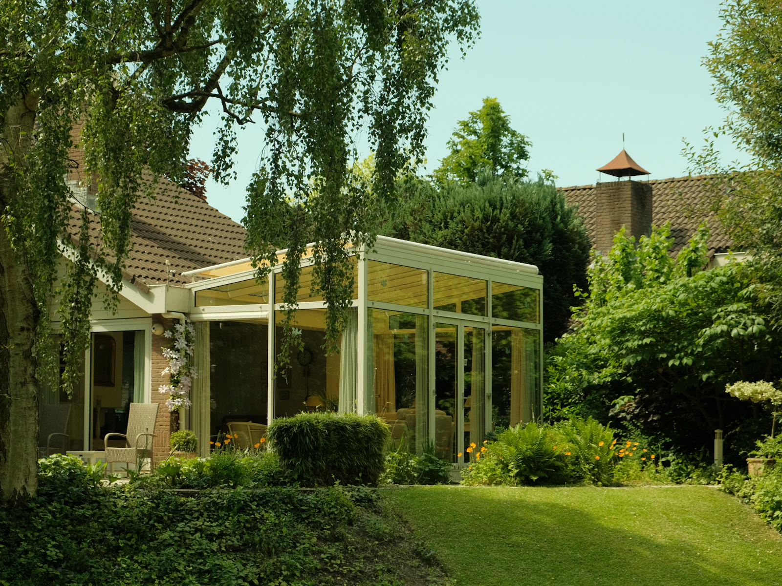 Illustrative photo of a glass sunroom addition surrounded by trees