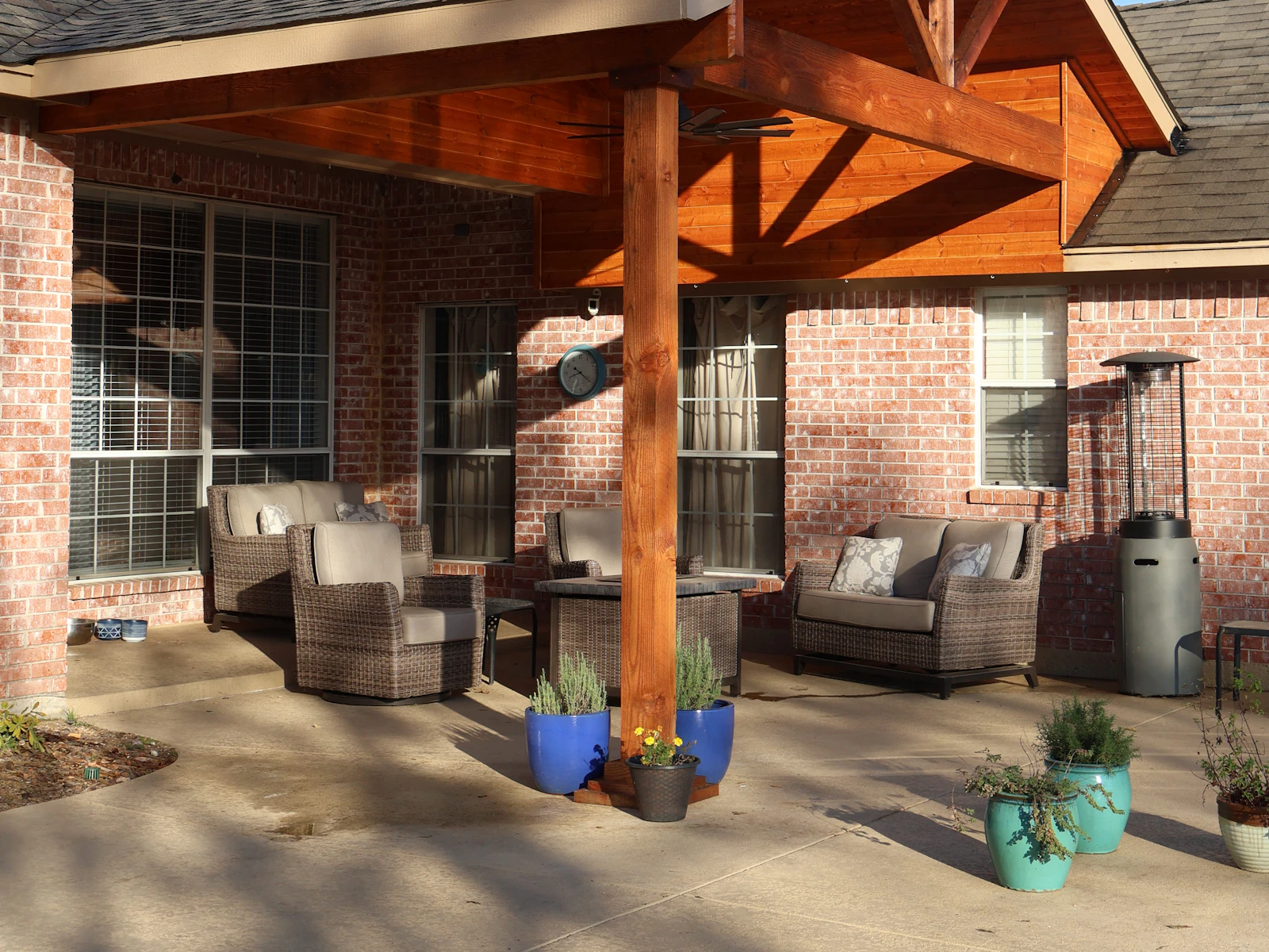 Illustrative photo of a brick home with a covered patio and outdoor furniture