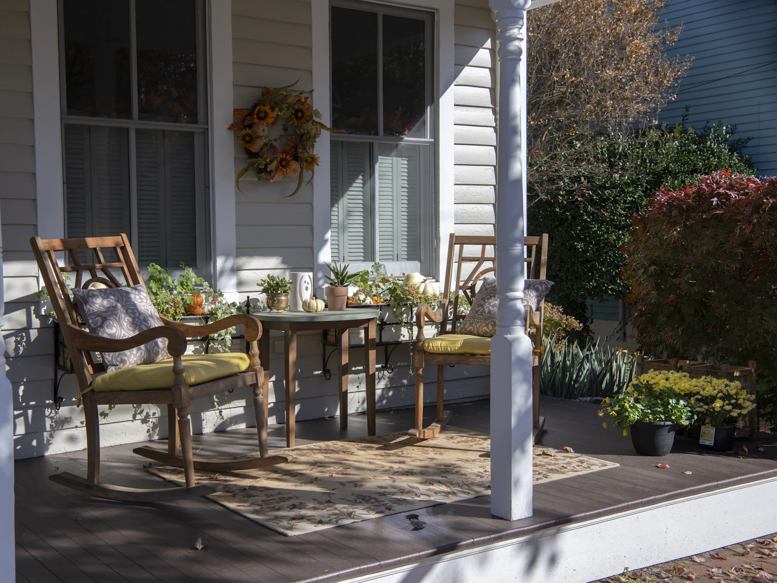 Illustrative photo of brown wooden chairs and table near white wooden post