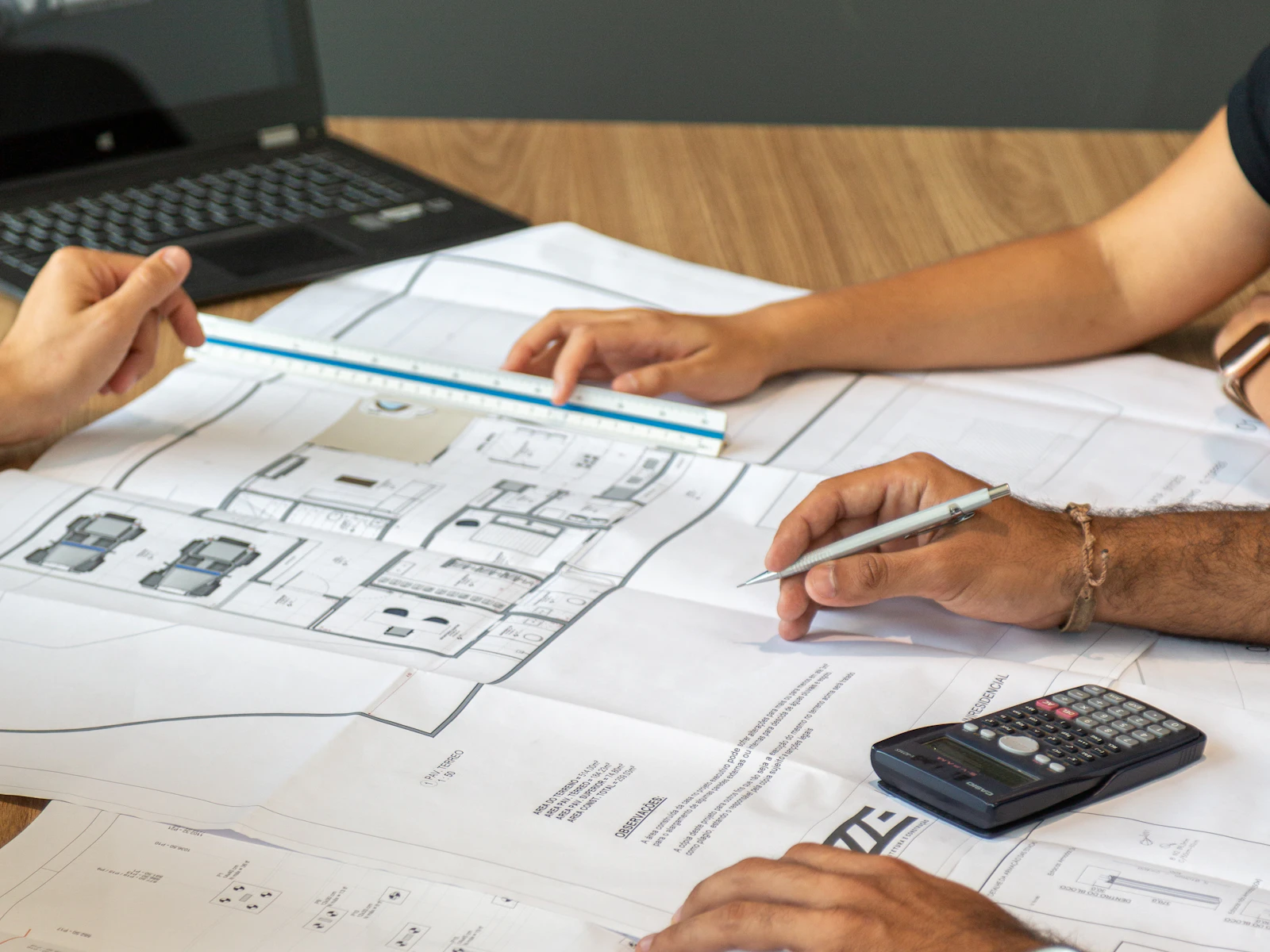 Illustrative photo of people reviewing architectural blueprints on desk