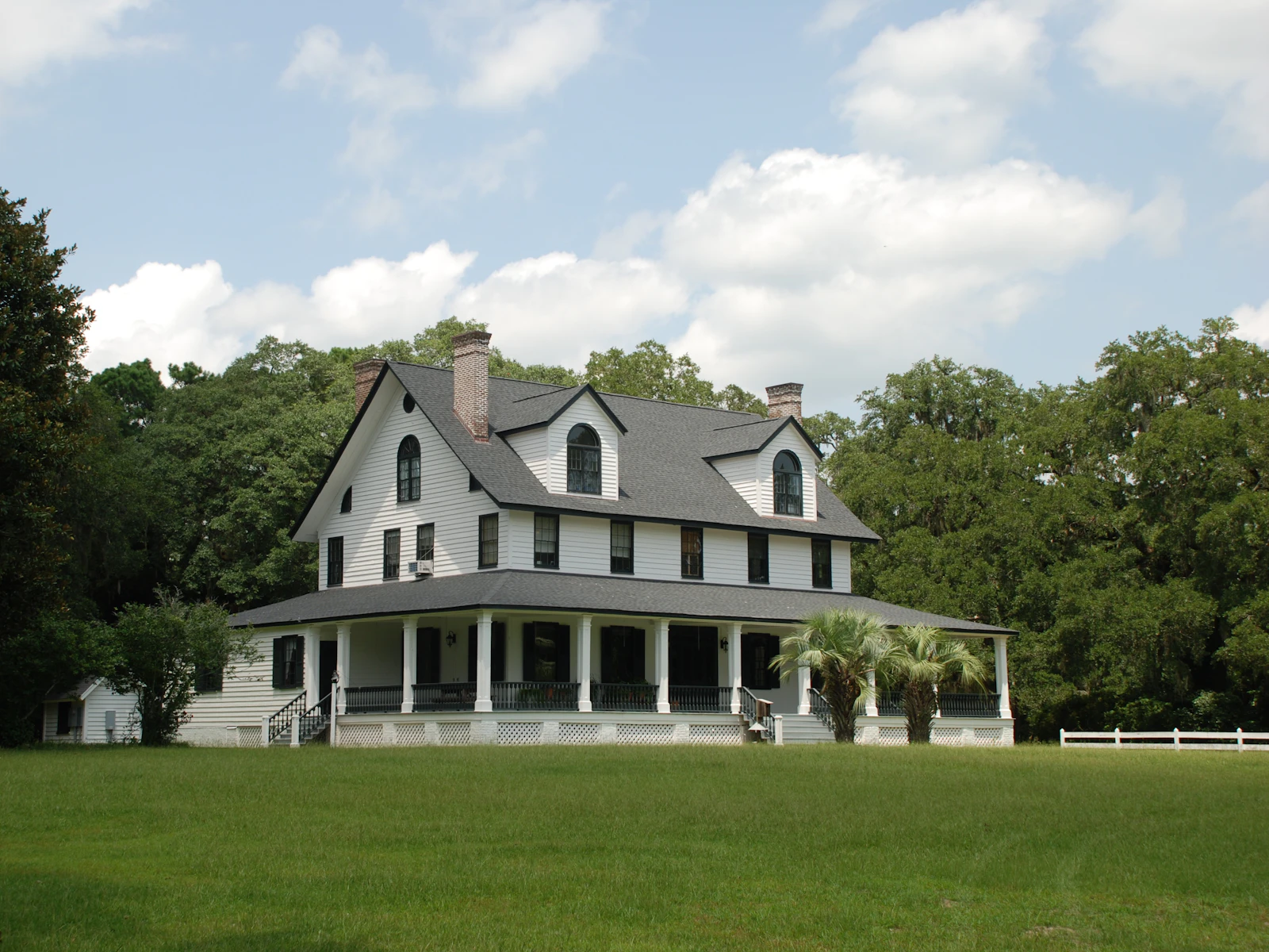 Illustrative photo of white and black house near green grass field during daytime