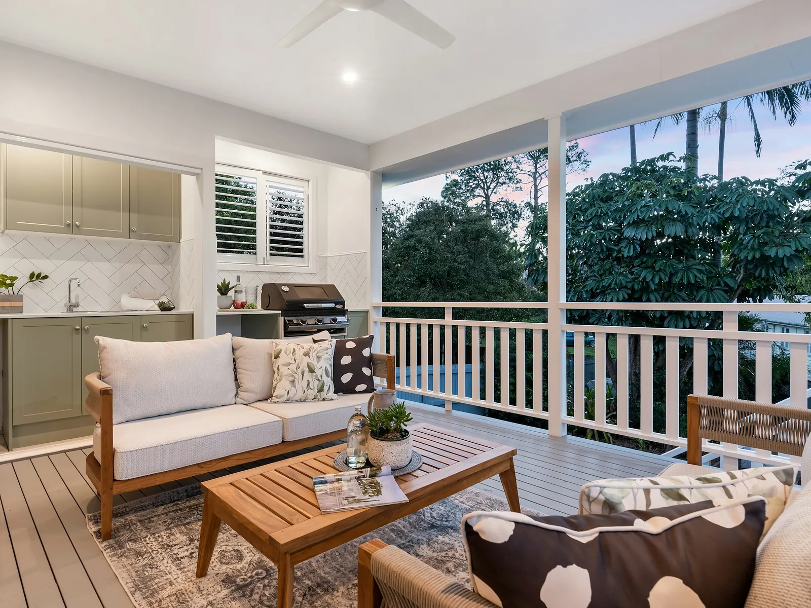 Illustrative photo of a covered porch with an outdoor kitchen, a sofa and a coffee table